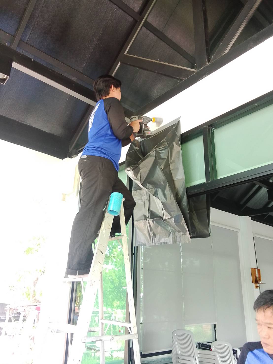 ทีมงานขึ้นบันไดติดตั้งคอยล์เย็นใต้เพดาน