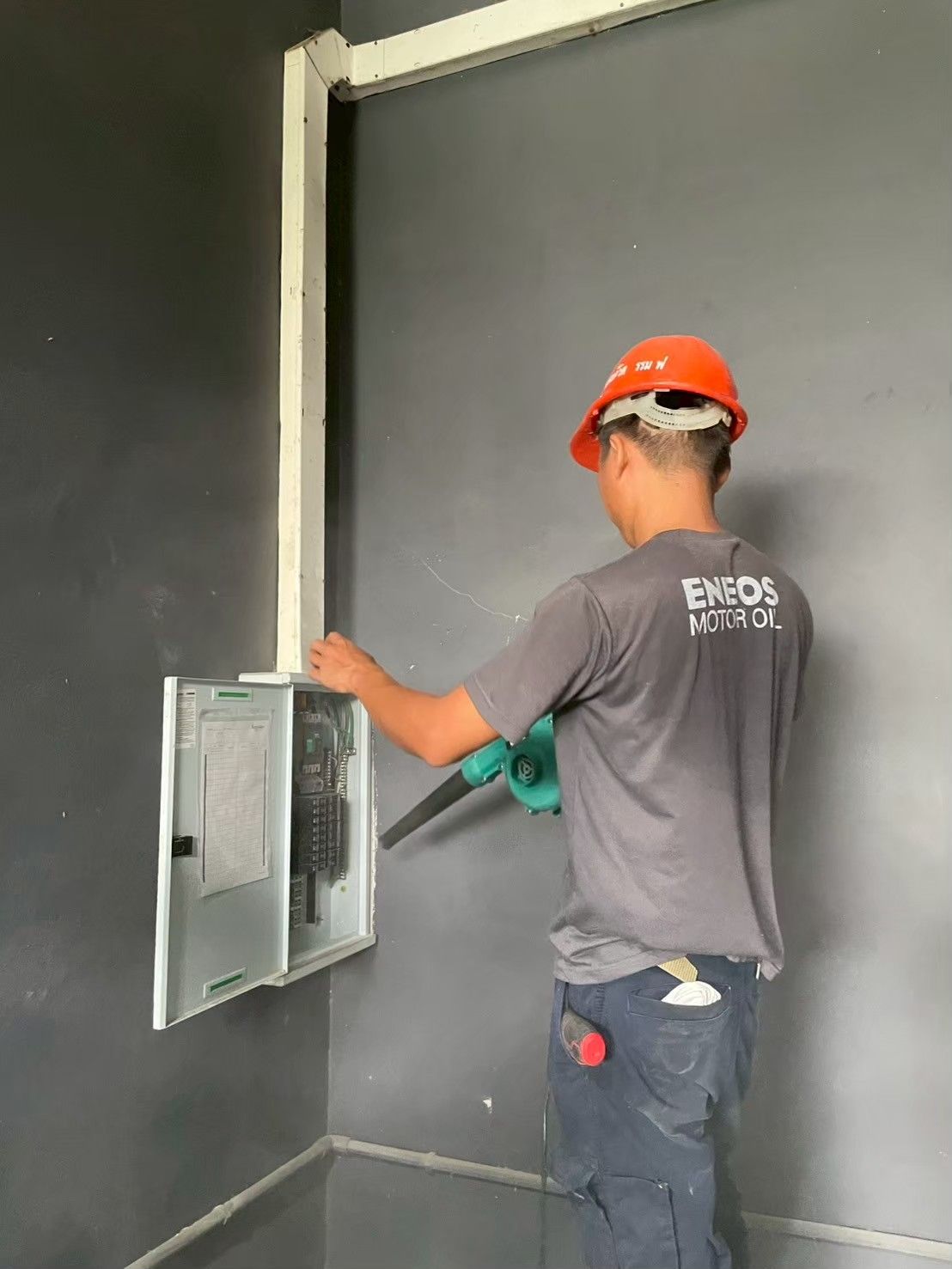 ช่างเป่าฝุ่น DB panel ผนังสีเทา