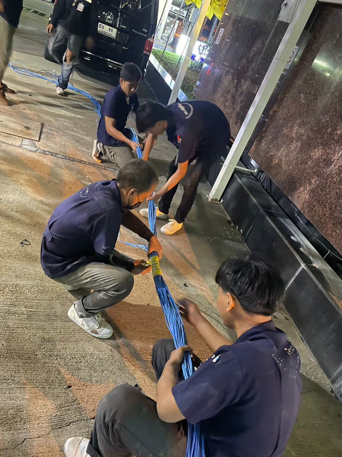 ทีมช่างดึงและมัดสายเคเบิลชุดใหญ่ นอกอาคารช่วงกลางคืน รพ.วิชัยยุทธ