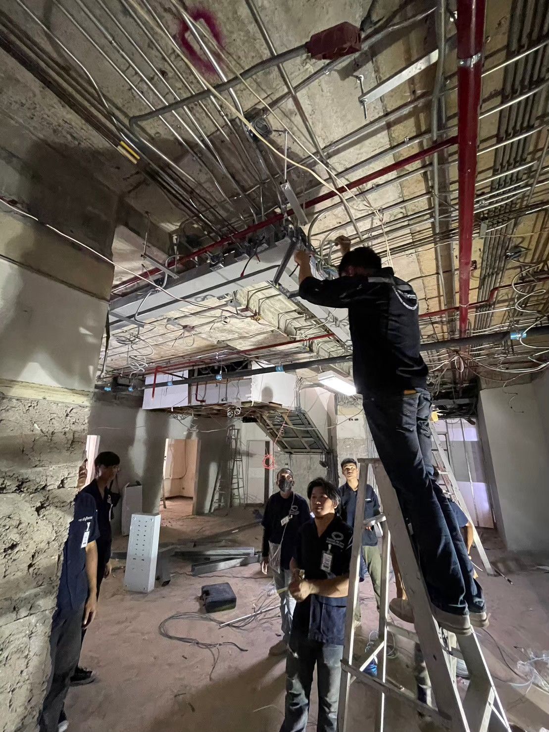 งานเดินท่อร้อยสายไฟเหนือฝ้าเพดาน ช่างทำงานบนบันได ชั้น 1 ตึกเหนือ รพ.วิชัยยุทธ